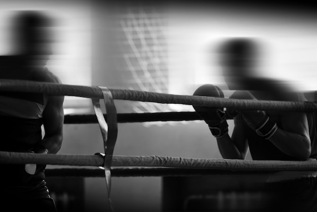 Silhouettes noires et blanches d'athlètes de boxe dans le ring Sports de combat Faible profondeur de champ se concentrer sur les mains des athlètes