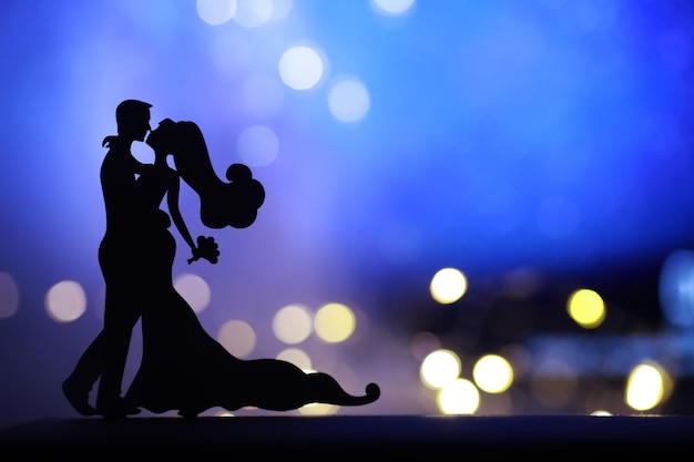 Silhouettes noires de paires de danseurs exécutant L'homme et la femme dansent sur fond gris avec rétro-éclairage blanc Chorégraphie Bal du Nouvel An