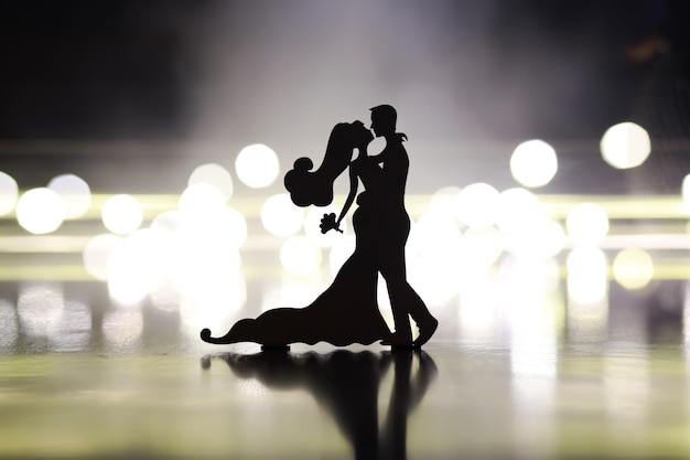 Silhouettes noires de paires de danseurs exécutant L'homme et la femme dansent sur fond gris