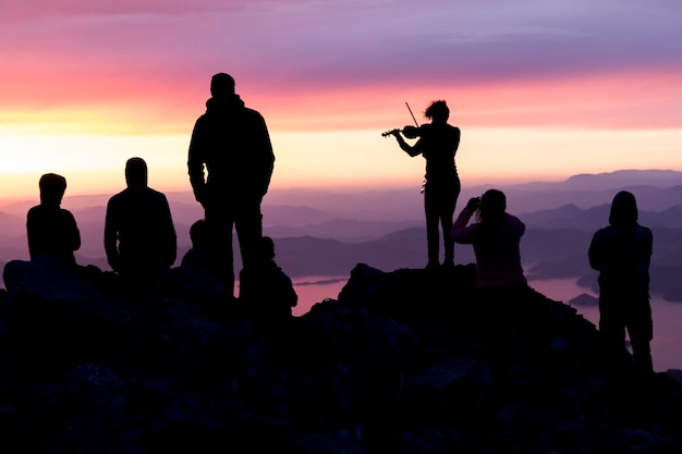 Silhouettes de personnes au sommet d'une montagne