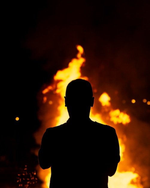 Silhouettes de personnes autour d'un feu de joie dans la nuit de San Juan