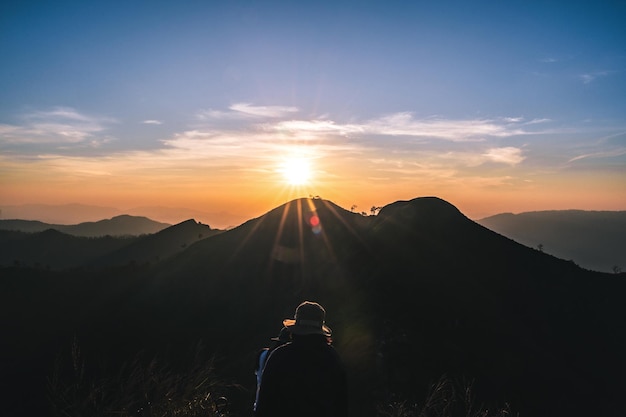 Des silhouettes de personnes avec une belle vue sur le coucher de soleil et des couches de montagnes sur le mont Khao Khao Chang Phueak. La plus haute montagne du parc national de Thong Pha Phum est connue sous le nom de Khao Chang Fueak.