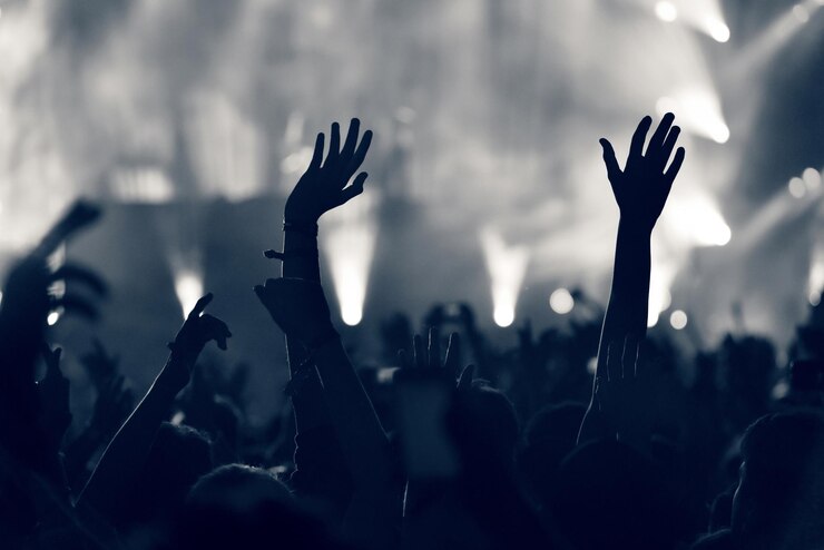 Photo des silhouettes de personnes lors d'un concert de musique contre le ciel la nuit