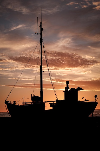 Photo silhouettes de voiliers amarrés sur la mer contre le ciel au coucher du soleil