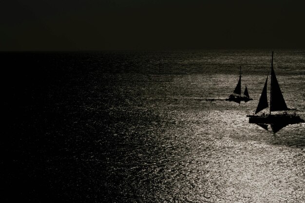 Photo silhouettes de voiliers en mer la nuit