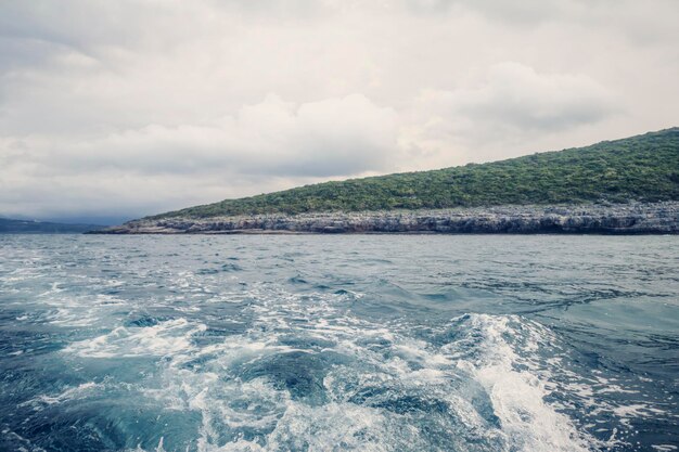 Sillage du bateau et du rivage, Ciel nuageux