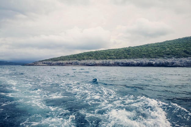 Sillage du bateau et du rivage, Ciel nuageux