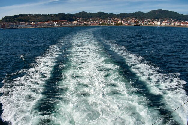 Le sillage du navire avec la ville de Cangas do Morrazo en arrière-plan