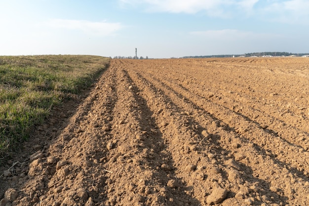 Sillons profonds dans le sol après avoir travaillé le tracteur avec la charrue Labourer le traitement des terres de la couche supérieure du sol pour saturer le sol en oxygène et détruire les graines et les racines des mauvaises herbes