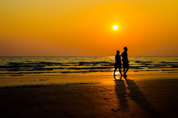 Siloriser les amoureux et la plage avant le coucher du soleil