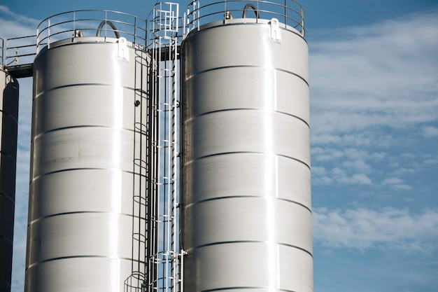 Silos en acier inoxydable dans l'industrie chimique silo de plastique en vrac contre un soleil orange