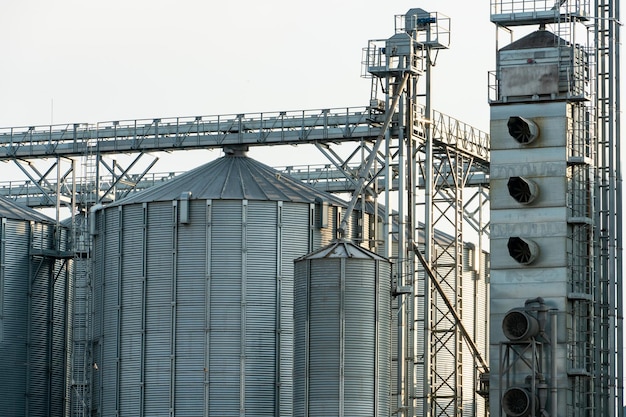 Photo silos d'argent sur l'agro-usine de fabrication pour le traitement, le séchage, le nettoyage et le stockage des produits agricoles farine céréales et grains grands barils de fer de grain ascenseur de grenier