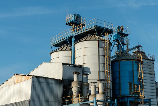 Silos d'argent sur l'agro-usine de fabrication pour le traitement, le séchage, le nettoyage et le stockage des produits agricoles farine céréales et grains Grands barils de fer de grain Ascenseur de grenier