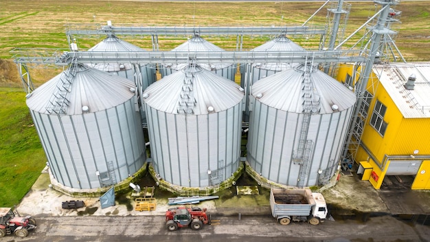 Silos d'argent sur une usine agro-industrielle pour le traitement, le séchage, le nettoyage et le stockage de produits agricoles farine céréales et céréales Voler un drone au-dessus de barils de fer de grain photo quadcopter