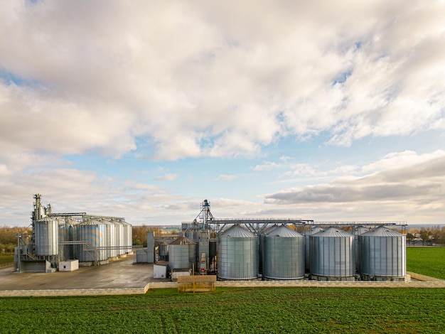 Silos d'argent sur une usine de fabrication agricole pour le traitement, le séchage, le nettoyage et le stockage de produits agricoles farine céréales et céréales Voler un drone au-dessus de barils de fer de grain photo quadcopter