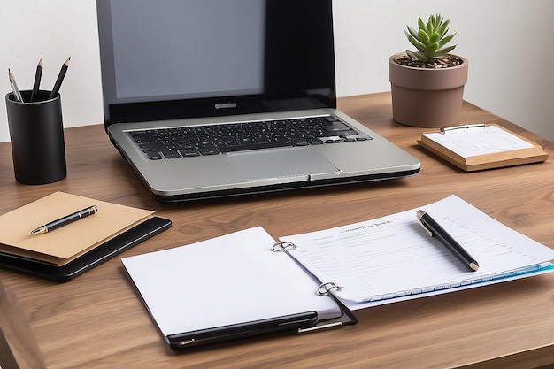 Un simple bureau en bois avec un bloc-notes et un ordinateur portable