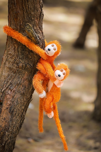 Singe jouet orange sur arbre dans le parc Mise au point sélective