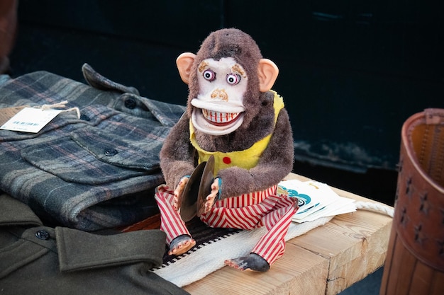 Photo singe jouet vintage avec cymbales chimpanzé joyeux sur un comptoir en bois avec des vêtements