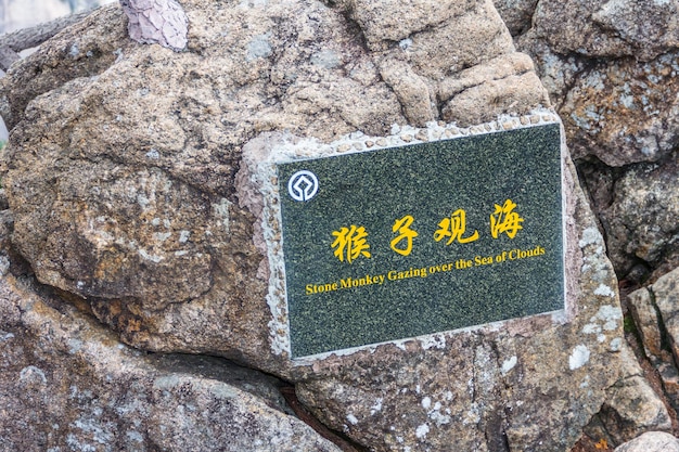 Singe de pierre regardant au-dessus de la mer de nuages Mont Huangshan Chine