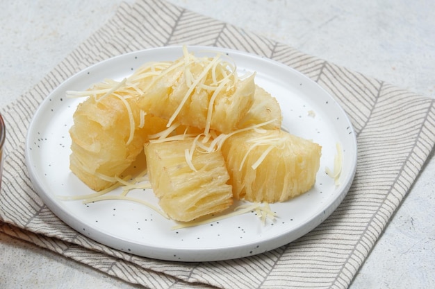 singkong kejudeep Manioc frit saupoudré de fromage râpé et de lait blanc concentré sucré