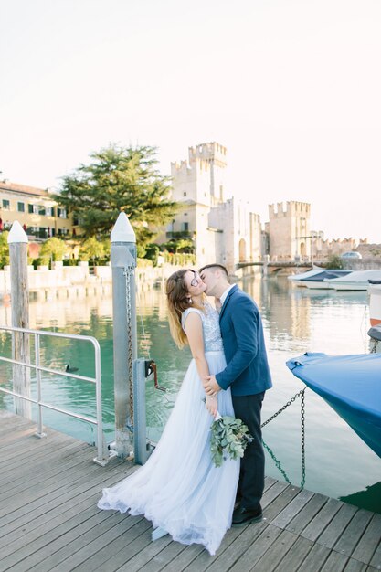 Sirmione, Lago di Garda, Italie. Charmant couple amoureux étreignant et embrassant sur le pont de Sirmione