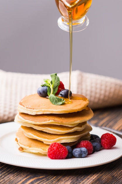 Sirop d'érable versé sur pile de mini crêpes