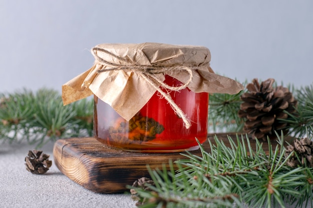 Sirop de pommes de pin dans un bocal en verre sur planche de bois