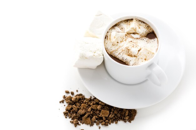 Siroter du chocolat dans une tasse blanche avec des guimauves.