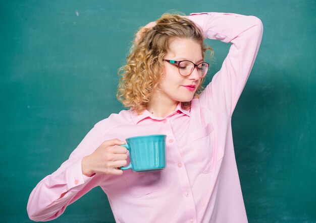 Siroter recharger le corps et l'esprit Dose de caféine Retour à l'école Accro au café Charge d'énergie pour toute la journée Les lunettes de l'enseignant boivent du café sur fond de tableau Une femme savoure un café avant les cours