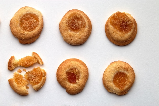 Six biscuits faits à la main avec de la confiture d'abricots disposés en rangées égales isolé sur fond blanc