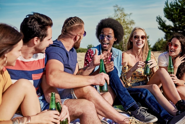 Six jeunes buvant de la bière à l'extérieur