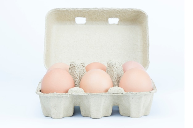 Six oeufs dans le papier bac carton brun boîte isolé fond blanc avec un tracé de détourage.