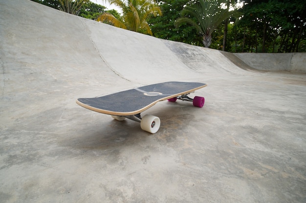 Skateboard longboard dans skate park avec bol en béton ou piscine.