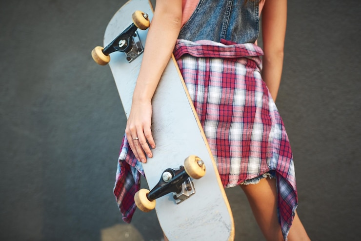 Photo skateboard et mur féminin en ville pour le sport, le passe-temps et les loisirs en plein air avec récréation ou compétence arrière skateboard féminin et activité en ville pour l'aventure de fitness et l'exercice le week-end