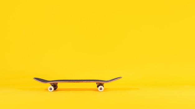 Skateboard professionnel isolé sur fond jaune.