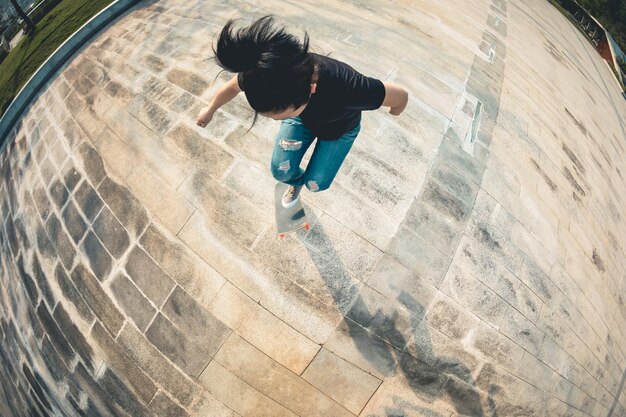 Photo skateboarder faisant du skateboard en plein air le matin