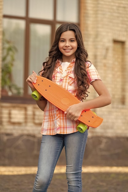 skateboarding de fille adolescente heureuse skateboardage en plein air de fille adolescente à l'extérieur skateboard de fille adolescente dans la rue photo de fille adolescente sur skateboard