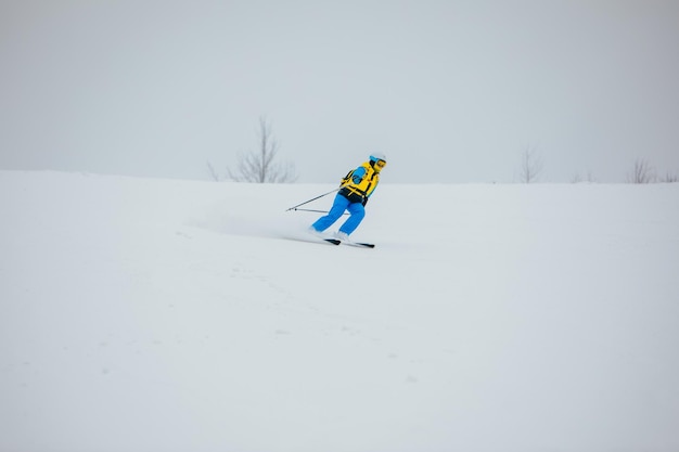 Skieur de femme au sport extrême d'hiver de pente de ski