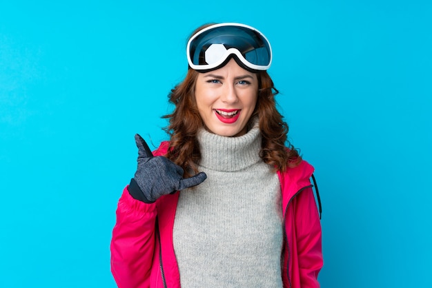 Skieur femme avec des lunettes de snowboard sur mur isolé