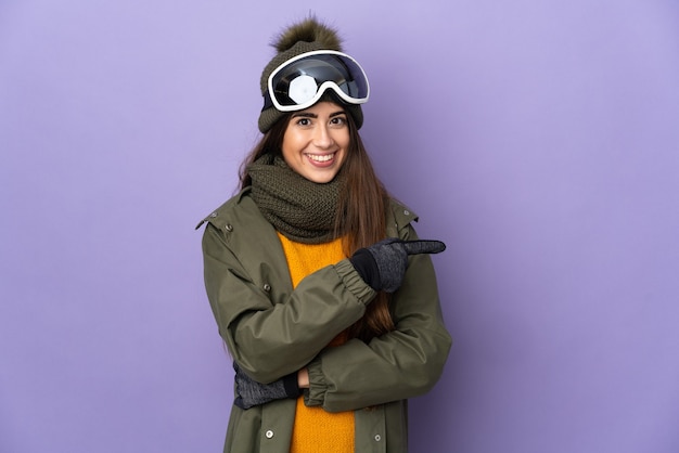 Skieur fille caucasienne avec des lunettes de snowboard isolé