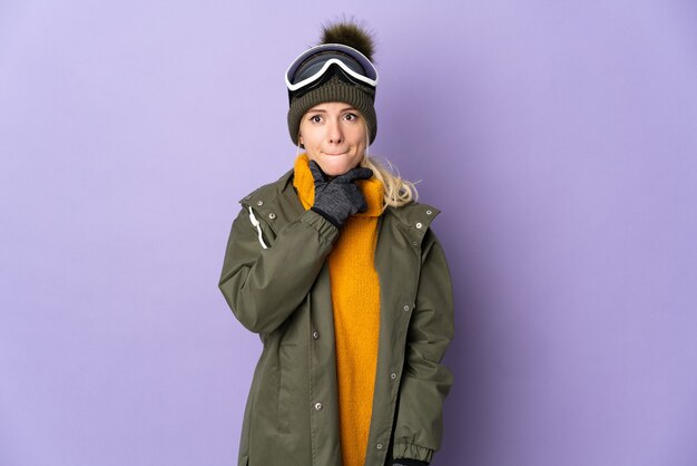 Skieur fille russe avec des lunettes de snowboard isolé sur fond violet ayant des doutes et de la pensée