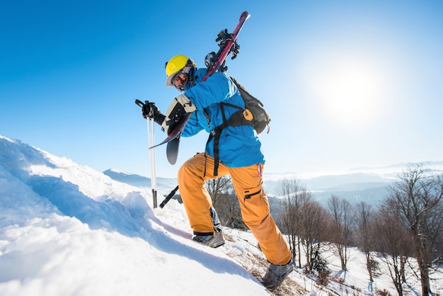 Skieur marchant sur la colline enneigée