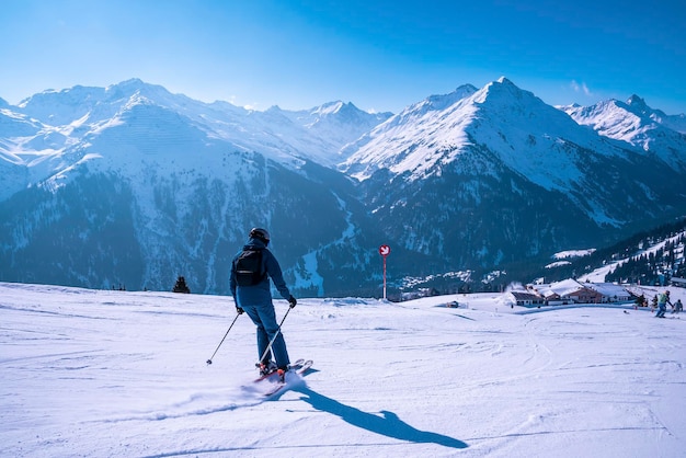 Skieur masculin skiant sur un paysage enneigé contre une chaîne de montagnes