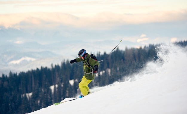 Skieur en ordre décroissant de pic de haute montagne couvert de neige