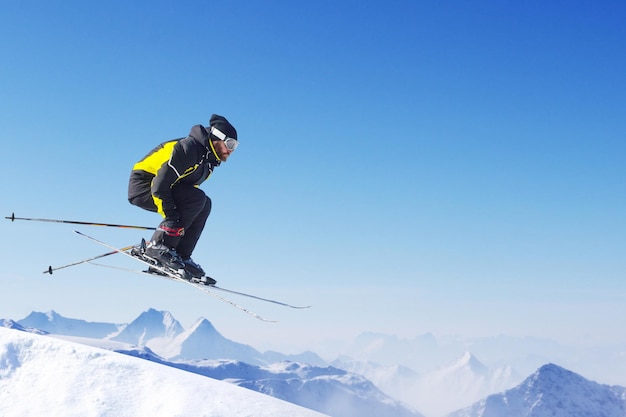 Skieur sautant au saut avec de hautes montagnes alpines