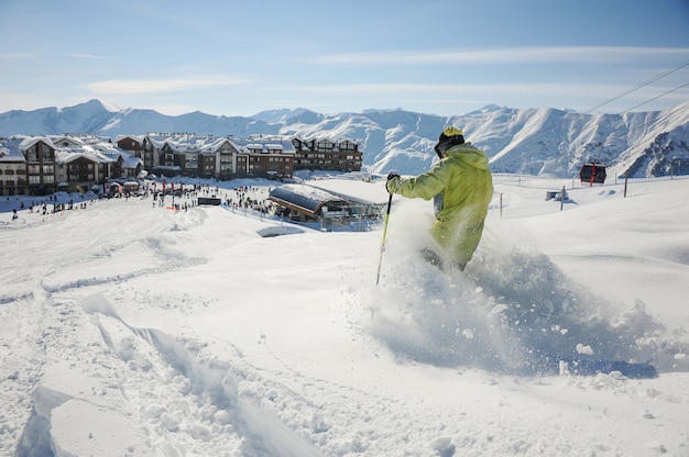 Skieur en sportswear jaune descendant la pente en Géorgie, Gudauri