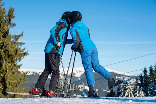 Skieurs couple, baisers, sur, sommet montagne, à, montagne, et, ciel bleu, dans, fond