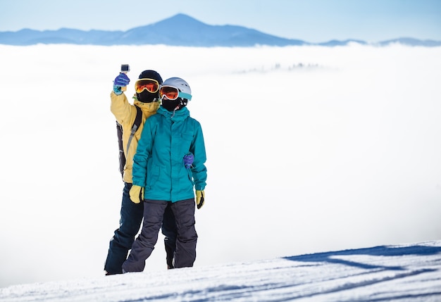 Les skieurs se prenant en photo avec un smartphone sur une montagne