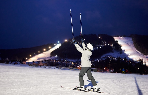 Skieuse méconnaissable avec les mains avec des bâtons de ski