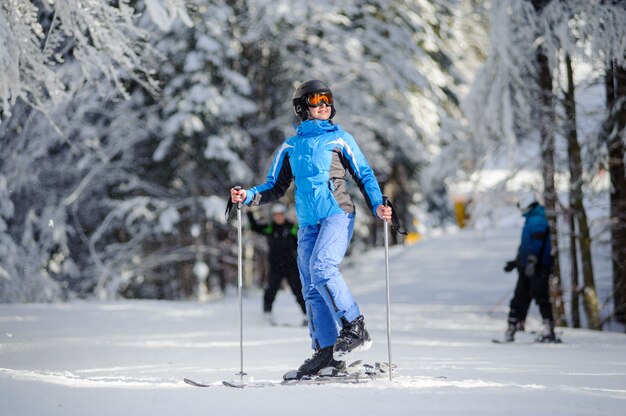 Une skieuse met ses skis et regarde au soleil par une journée ensoleillée